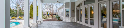 a covered patio with windows and a pool