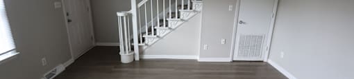 A room with a staircase and white doors.