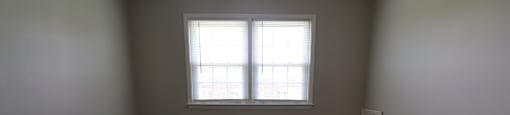 A room with a carpeted floor and a window.
