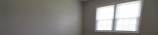 A room with a carpeted floor and a window.