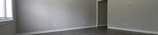 A room with a ceiling fan and wooden flooring.