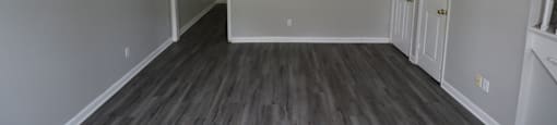 A room with a ceiling fan and wooden flooring.