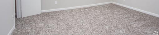 an empty room with carpet and a window