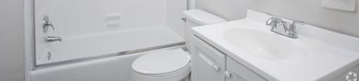 a white bathroom with a shower sink and toilet