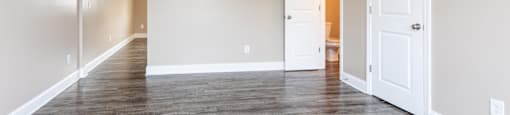 A room with a ceiling fan and wooden flooring.