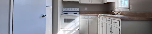 A white refrigerator in a room with grey walls.