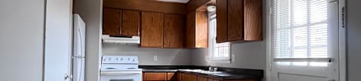 A modern kitchen with a white countertop and a staircase leading to the upper level.