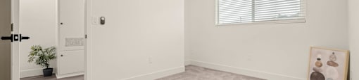 an empty living room with a ceiling fan
