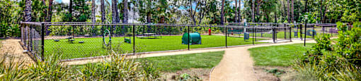 a path leading to a park with a playground and trees at Monterra Ridge Apartments,California
