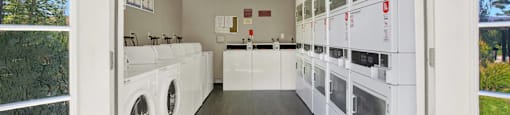 a laundry room with washers and dryers and a window at Monterra Ridge Apartments, California,91351