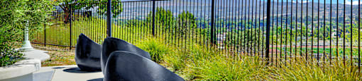 a group of chairs sitting in front of a fence at Monterra Ridge Apartments, Canyon Country ,91351
