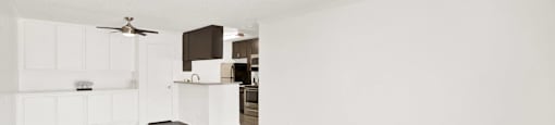 an empty living room and kitchen with white walls and wood flooring at Monterra Ridge Apartments,California