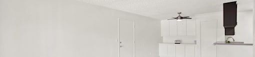 an empty living room with white walls and wood floors at Monterra Ridge Apartments, Canyon Country, California