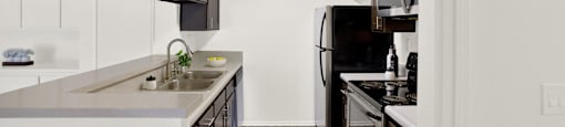 a kitchen with a sink and a stove and a refrigerator at Monterra Ridge Apartments, Canyon Country ,91351
