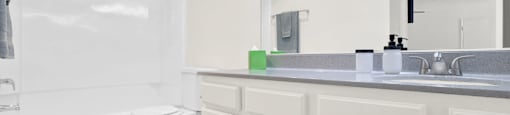 a bathroom with a large mirror and a toilet and a sink at Monterra Ridge Apartments, Canyon Country, California