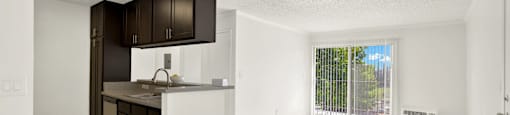an empty kitchen and living room with a sliding glass door to a balcony at Monterra Ridge Apartments, California,91351