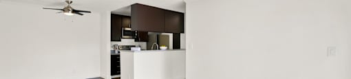 an empty living room and kitchen with a ceiling fan at Monterra Ridge Apartments, Canyon Country