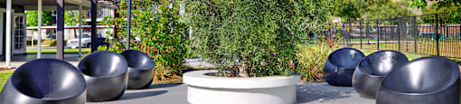 a seating area with metal benches and a tree at Monterra Ridge Apartments, Canyon Country