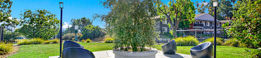 a seating area with a tree in a park at Monterra Ridge Apartments, Canyon Country, California