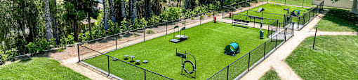 a tennis court in a park with trees at Monterra Ridge Apartments,California