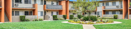the view of an apartment building with a yard and grass at Sunset Square Apartments, West Covina, California, 91790