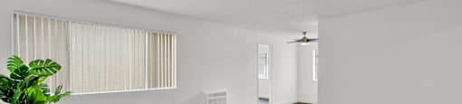 the living room and dining room of an apartment with white walls and wood flooring at Sunset Square Apartments, West Covina, California, 91790