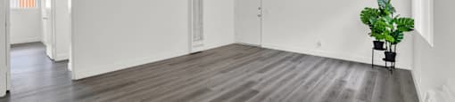 an empty living room with white walls and wood floors at Sunset Square Apartments, West Covina, California, 91790