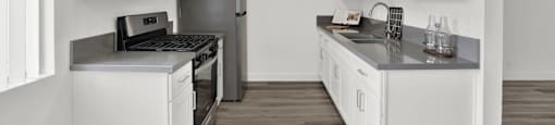 a kitchen with white cabinets and stainless steel appliances at Sunset Square Apartments, West Covina, California, 91790