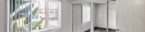 Bedroom view with mirrored closet doors at Serrano Apartments, West Covina, CA, 91790