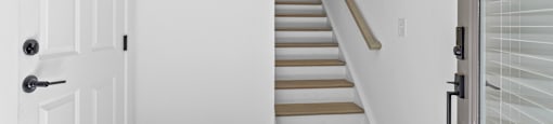 a staircase in a home with white walls and wood floors at The Collection Charlotte in Charlotte, NC, 28205