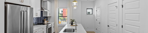 a large kitchen with white cabinets and stainless steel appliances at The Collection Charlotte in Charlotte, NC, 28205