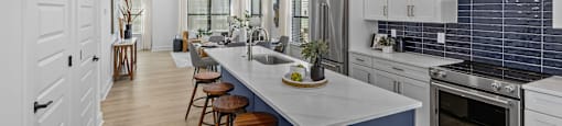 a large kitchen with a blue island and white cabinets at The Collection Charlotte in Charlotte, NC, 28205