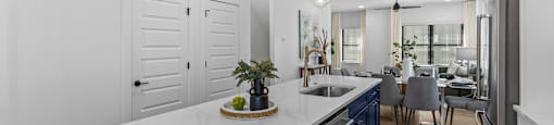 an open kitchen and dining room with blue cabinets and a white counter top at The Collection Charlotte in Charlotte, NC, 28205