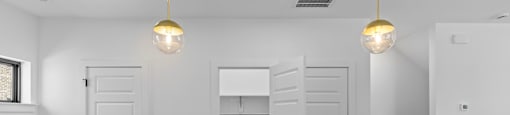 a white kitchen with a sink and two lamps at The Collection Charlotte in Charlotte, NC, 28205
