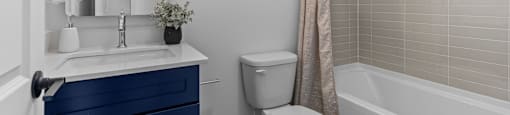 a bathroom with a toilet sink and tub and a window at The Collection Charlotte in Charlotte, NC, 28205