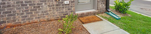 the front door of a brick apartment building with a wreath on the door at The Collection Charlotte in Charlotte, NC, 28205
