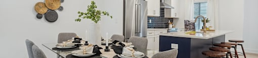 an open kitchen and dining room with a glass table and chairs at The Collection Charlotte in Charlotte, NC, 28205