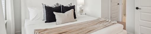 a bedroom with a white bed and a ceiling fan at The Collection Charlotte in Charlotte, NC, 28205