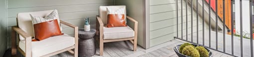 a balcony with two chairs and a table and a window at The Collection Charlotte in Charlotte, NC, 28205