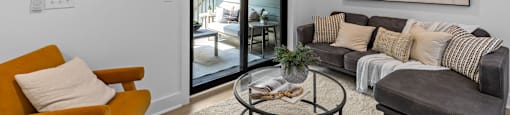 a living room with a ceiling fan and a sliding glass door to a patio at The Collection Charlotte in Charlotte, NC, 28205
