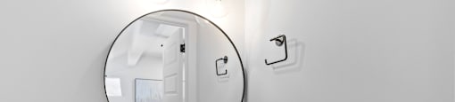 a white bathroom with a sink and a mirror at The Collection Charlotte in Charlotte, NC, 28205