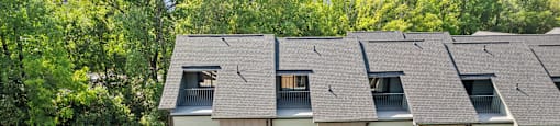 an aerial view of a building with a gray roof and trees at The Collection Charlotte in Charlotte, NC, 28205