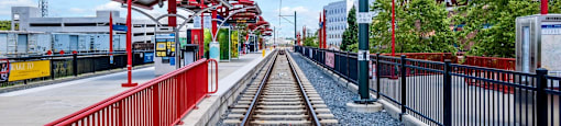 a train station with train tracks and a red and black fence at The Collection Charlotte in Charlotte, NC, 28205