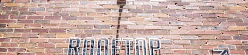 a brick wall with a sign on it that says root top beer garden at The Collection Charlotte in Charlotte, NC, 28205