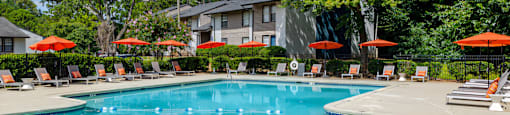 a swimming pool with chairs and umbrellas and a building in the background at Glen Hollow,Decatur, GA, 30034