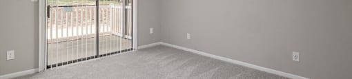 an empty living room with a sliding glass door to a balcony at Glen Hollow, Georgia 30034