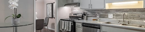a kitchen with white cabinets and stainless steel appliances and a dining table