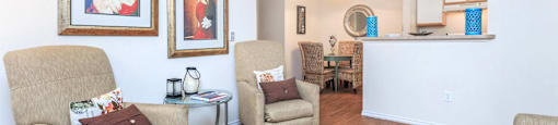 a living room with couches and chairs and a kitchen with a dining room table
