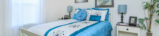 a bedroom with a white bed and blue comforter