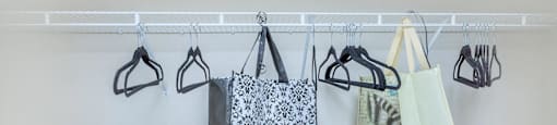 a row of bags hanging from a rack on a wall